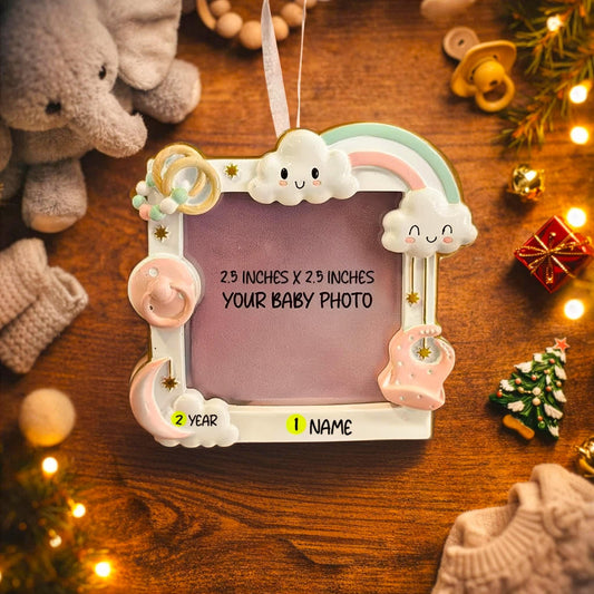 Decorative photo frame with baby-themed elements on a wooden surface.