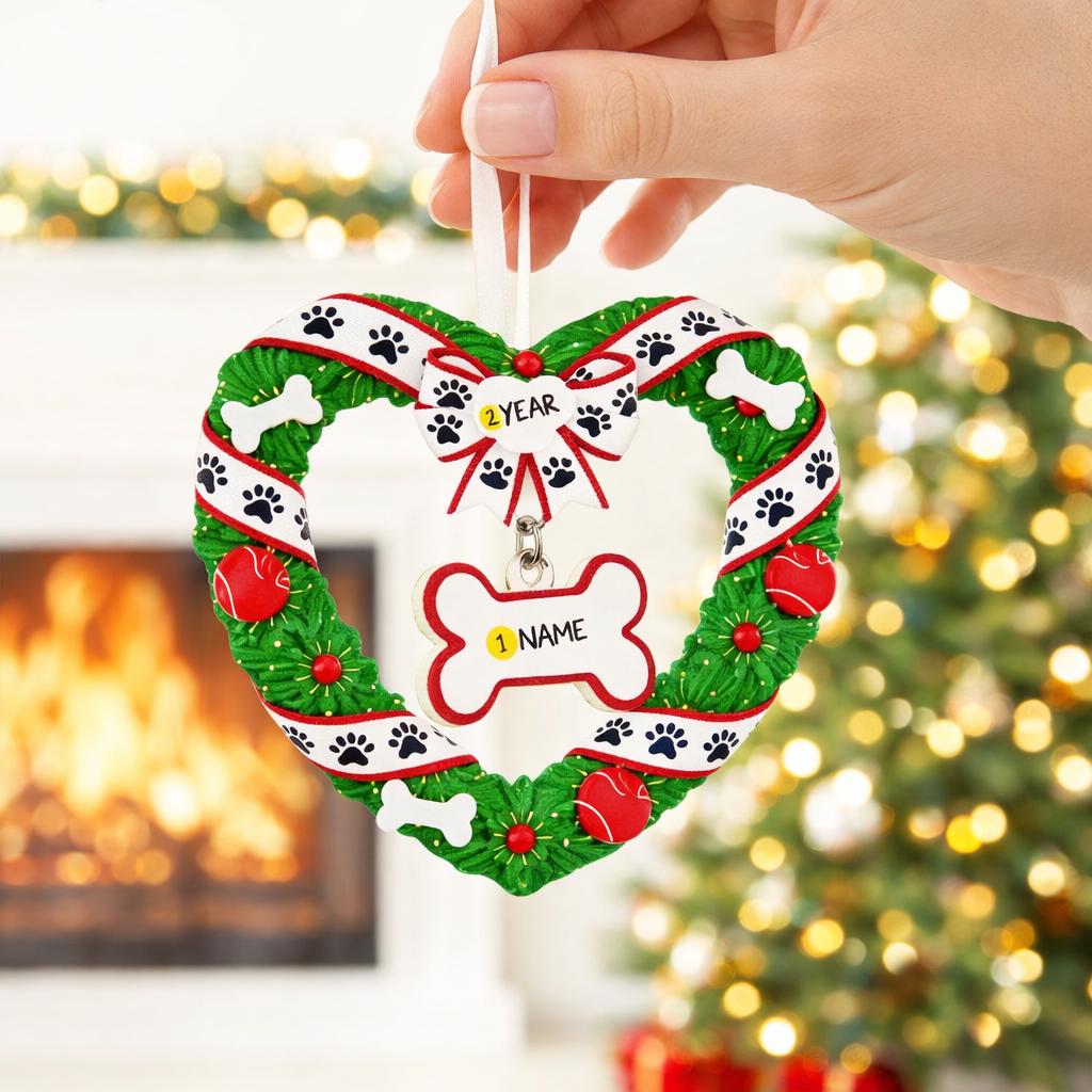 Heart-shaped Christmas ornament with paw prints and a name tag, held against a festive background.