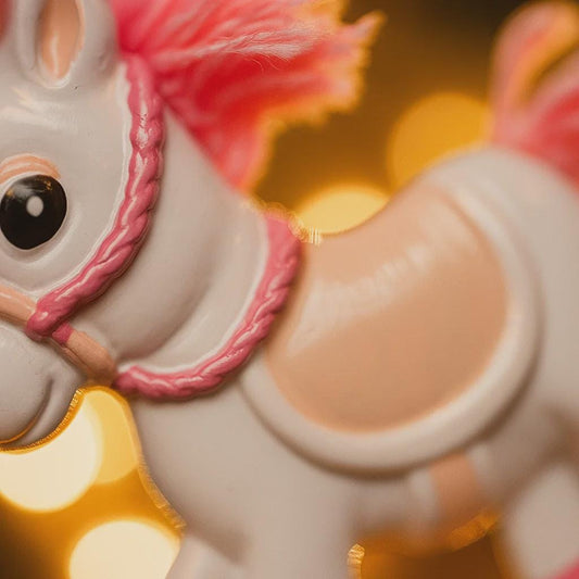 Close-up of a ornament horse with a pink bridle on a blurred background