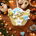 Load image into Gallery viewer, Personalized Baby First Christmas Ornament featuring a sweet newborn tucked inside a cozy woven basket with a soft blue star hat and matching blanket. This 3D front design includes raised details, textured knit pattern, and adorable teddy bear accent, creating depth and charm. Name is displayed on the hat and year on the star. A heartfelt keepsake for baby’s first holiday, nursery decor, or newborn gift. Perfect Christmas tree ornament for new parents.
