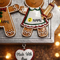 Load image into Gallery viewer, Decorative gingerbread man and woman ornament with 'Made with Love' heart tag on a blurred background.

