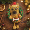 Load image into Gallery viewer, Dog-shaped Christmas ornament in a wreath on a wooden surface with festive decorations.
