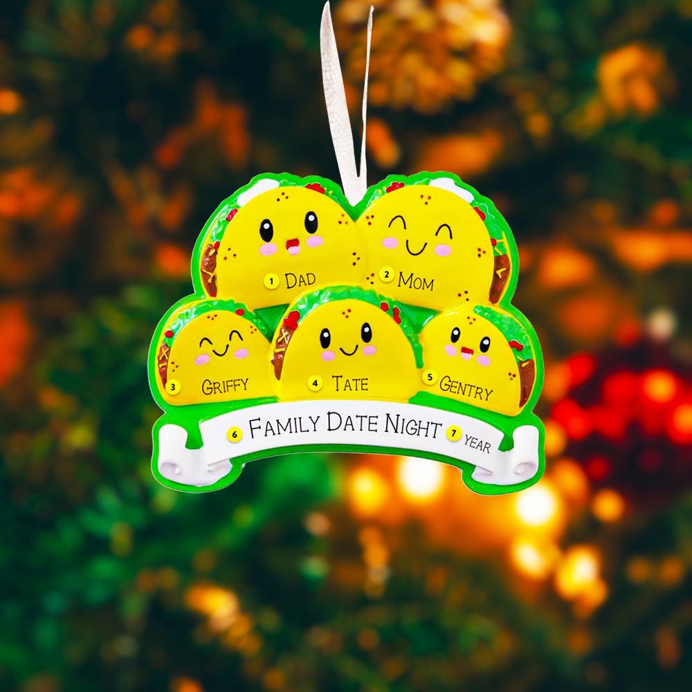 Decorative ornament shaped like a taco with cartoon faces on a Christmas tree.