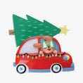 Load image into Gallery viewer, Festive dog themed Christmas ornament featuring a happy puppy riding in a red car with a Christmas tree on top. Designed with playful holiday colors and a cozy winter setting, this ornament brings a joyful pet themed touch to Christmas tree decor. Includes personalization options for name and year, making it a meaningful keepsake for dog lovers and pet families.
