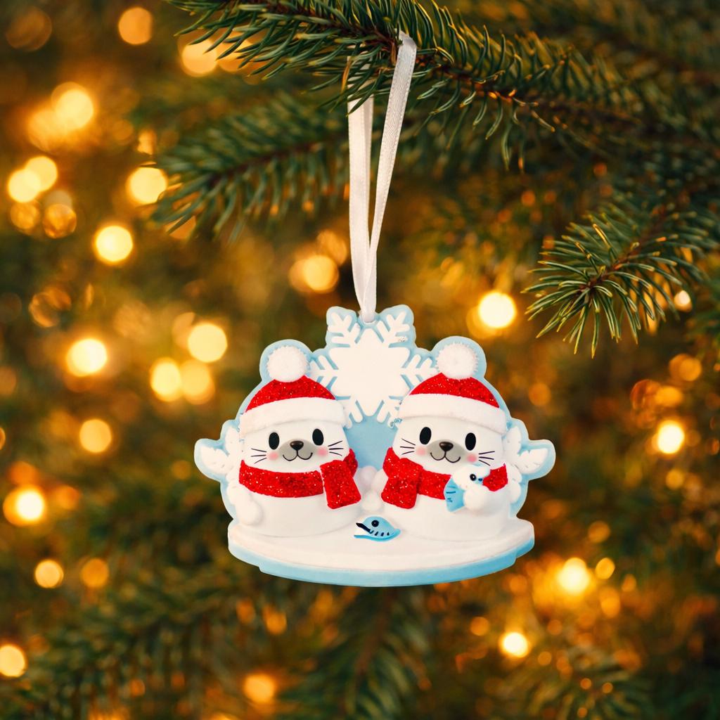 Christmas ornament with two seal characters in red hats and scarves on a tree with blurred lights in the background