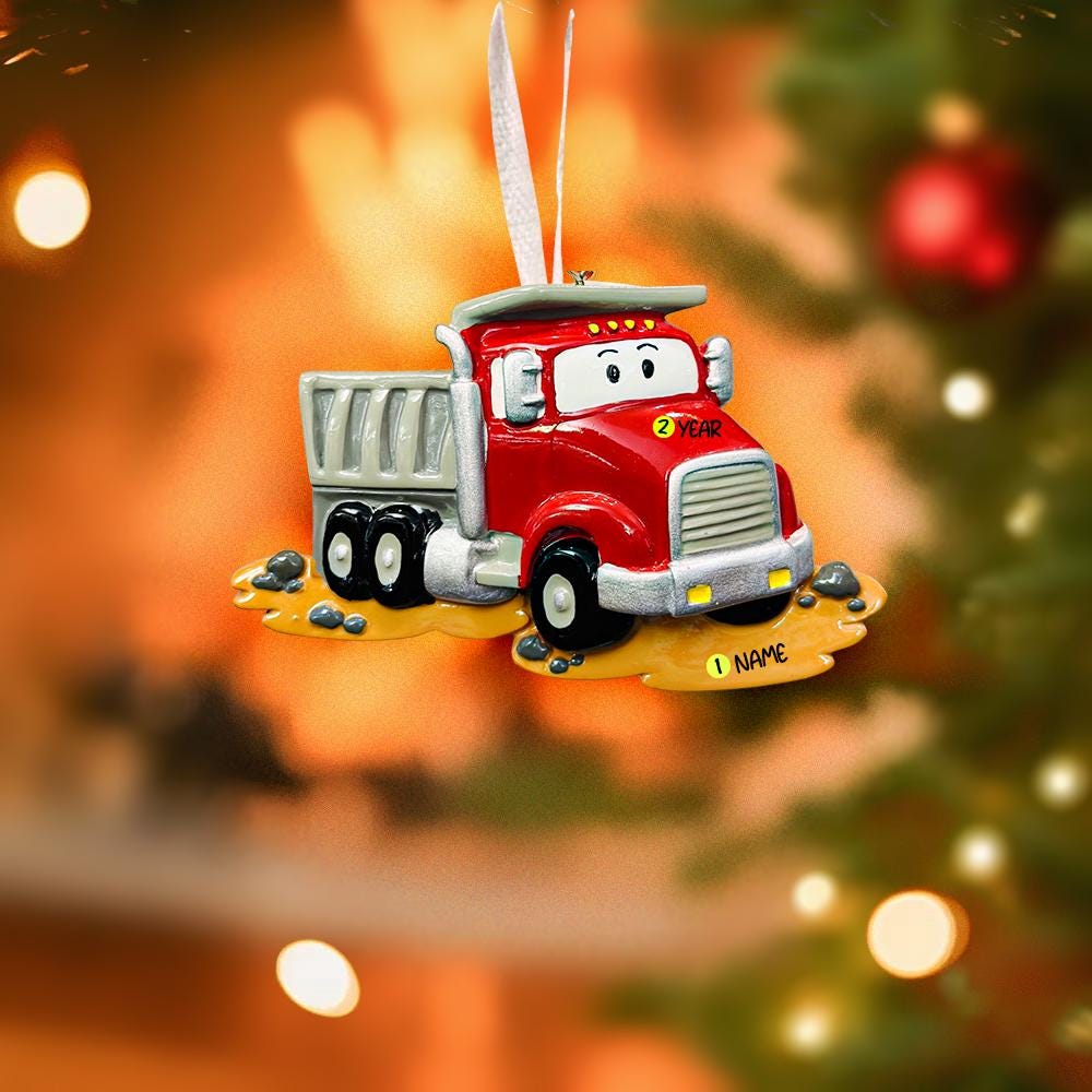 Red ornament truck on a Christmas tree with blurred lights in the background