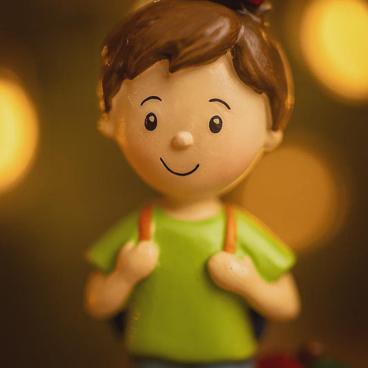Figurine of a boy with a green shirt against a blurred background