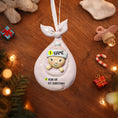 Load image into Gallery viewer, Personalized baby ornament with customizable text on a wooden surface with Christmas decorations.

