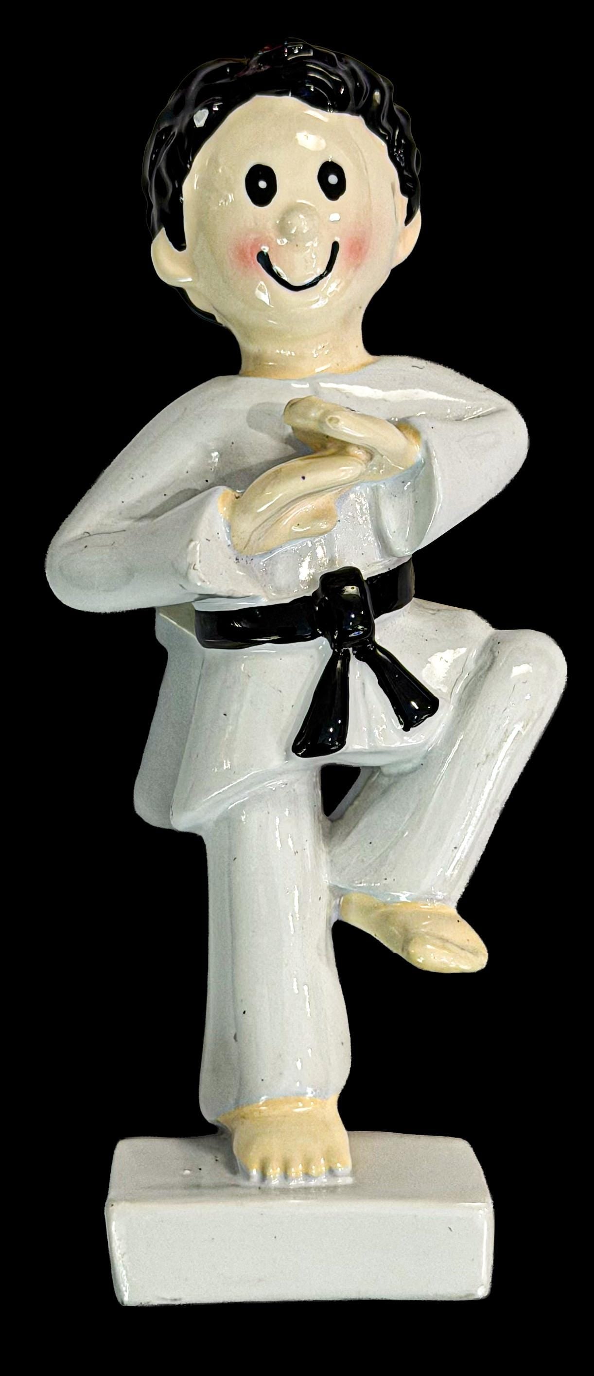 ornament of a martial artist in a white gi with a black belt on a black background