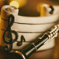 Load image into Gallery viewer, Clarinet leaning against a white bowl with decorative music notes on a warm-toned background
