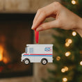 Load image into Gallery viewer, Hand holding a miniature postal truck ornament with a festive background
