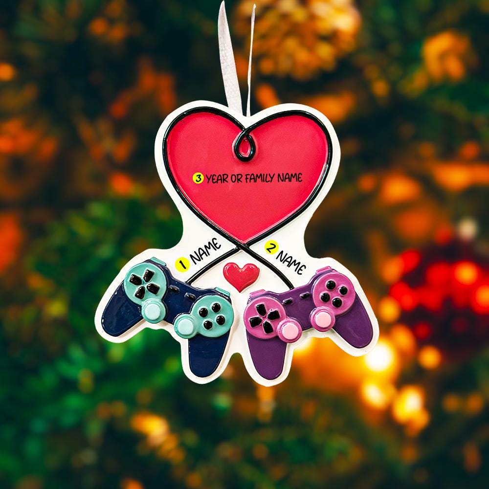 Gamer themed Christmas ornament featuring two game controllers connected with a heart design. Personalized with two custom names and a year or family name displayed on the ornament. Raised 3D details add texture and depth making it a unique holiday keepsake for gamer couples and gaming partners.