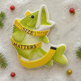 Load image into Gallery viewer, Decorative fish ornament with a measuring tape around its neck on a textured surface.
