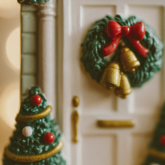Decorative Christmas tree and wreath magnets on a white surface