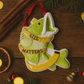 Load image into Gallery viewer, Decorative fish ornament with 'SIZE MATTERS' text on a wooden surface with Christmas decorations.
