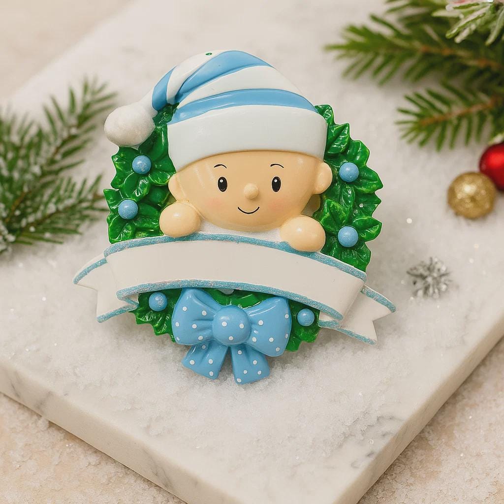 Personalized Baby Boy Christmas Ornament featuring a sweet child peeking from a festive green wreath with blue accents and polka dot bow. This ornament has a raised 3D front design with detailed holly leaves, textured elements, and dimensional lettering. The name is placed on the hat and the year on the banner. A meaningful keepsake for baby’s first Christmas, newborn gift, or holiday memory decoration for the Christmas tree.