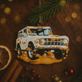 Load image into Gallery viewer, Decorative ornament shaped like a white SUV with orange mud splashes on a wooden surface with festive decorations.
