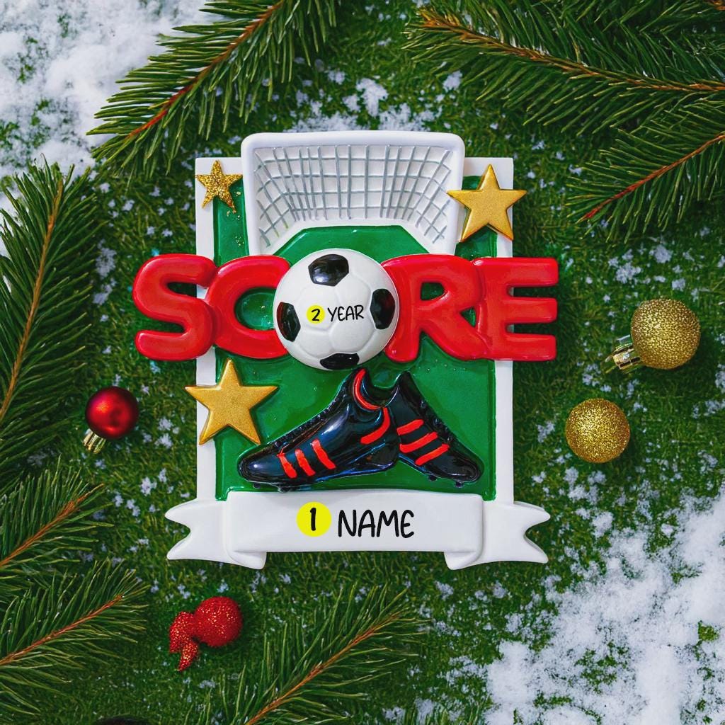 Soccer-themed ornament with 'Score' and '2 Year' text, surrounded by Christmas decorations on a green background.