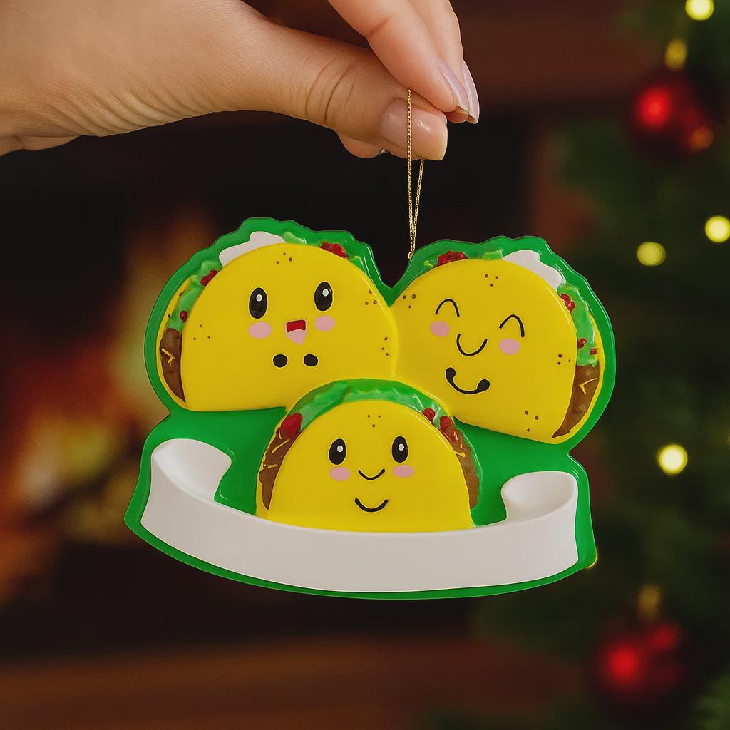 Decorative ornament shaped like a family of tacos with a blurred Christmas tree background.
