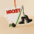 Load image into Gallery viewer, Hockey-themed ornament with 'HOCKEY' text, hockey stick, and skates on a beige background

