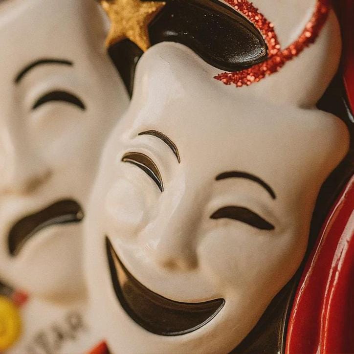 Close-up of a ceramic mask with a smiling expression and decorative elements.