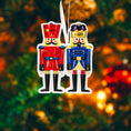 Load image into Gallery viewer, Festive close up of a personalized nutcracker couple ornament featuring two classic nutcracker figures in red and blue uniforms with custom name details. Designed for couples, partners, siblings, or loved ones, this ornament symbolizes balance, tradition, and togetherness. A timeless Christmas keepsake ideal for tree decor, holiday gifting, and celebrating meaningful bonds.

