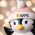 Load image into Gallery viewer, Personalized Baby Penguin First Christmas Ornament featuring a sweet penguin wearing a soft pink winter hat, sitting on a snowy base. The baby’s name is displayed on the hat and the year is placed on the belly, creating a meaningful keepsake for a newborn’s first holiday season. With bright yellow feet, soft winter details, and charming 3D design, this ornament is perfect for baby girls celebrating their very first Christmas and makes a thoughtful holiday gift for new parents.
