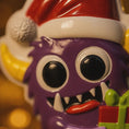 Load image into Gallery viewer, Purple monster toy with a Santa hat against a blurred background

