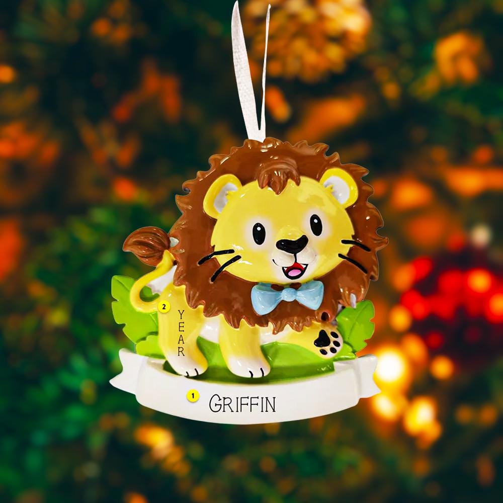 Lion themed Christmas ornament designed with a playful and colorful style, perfect for kids and animal lovers. This ornament features a lion character standing on a grassy base with a glossy finish and cheerful details. The design includes a personalization option, allowing a custom name and year to be added, making it a meaningful keepsake for children or family holiday traditions. Ideal for Christmas trees, nursery decor, or as a unique personalized gift for animal themed celebrations.