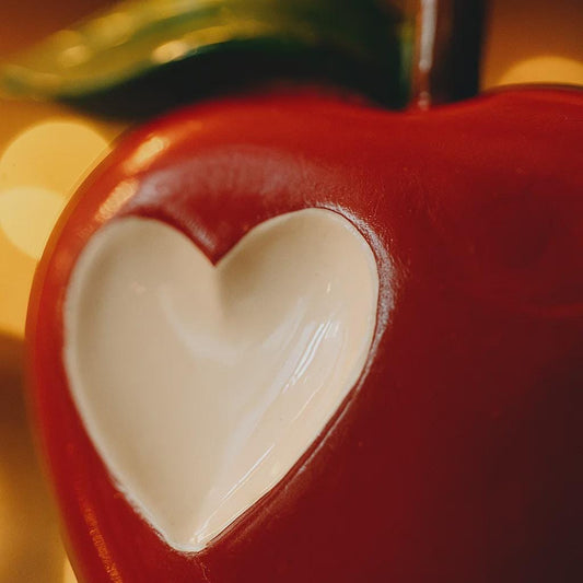 Close-up of a red ceramic heart-shaped object with a blurred background