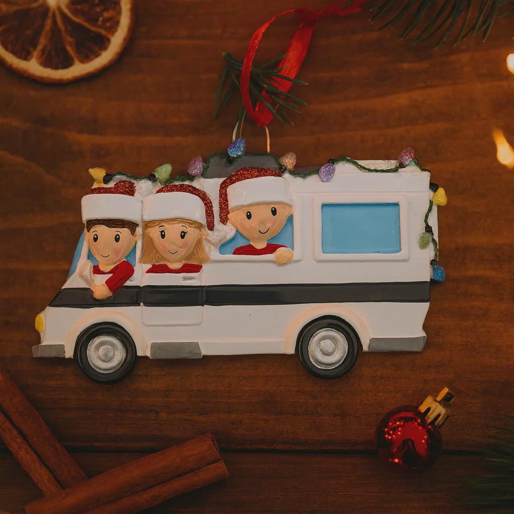 Christmas ornament of a family in a car with children wearing Santa hats on a wooden surface.