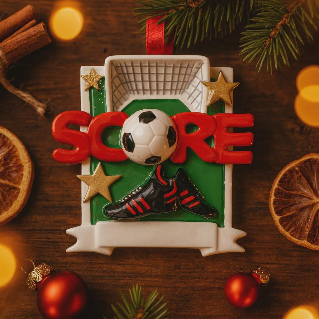 Christmas ornament with soccer ball, goal, and 'SCORE' text on a wooden background with decorations.