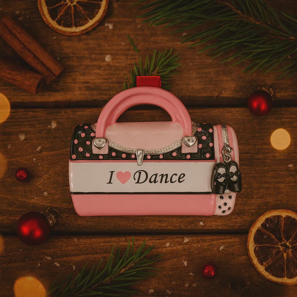 Decorative accessory shaped like a pink handbag with 'I ❤️ Dance' text on a wooden surface with Christmas decorations.