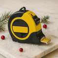 Load image into Gallery viewer, Yellow and black tape measure on a marble surface with Christmas decorations.
