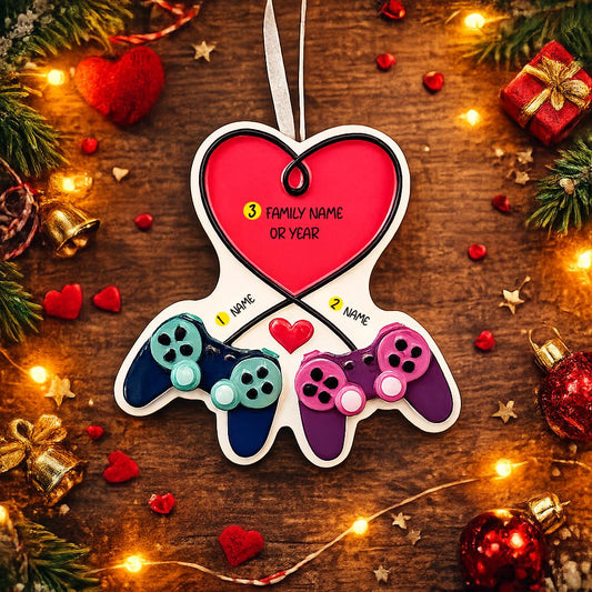 Gamer themed Christmas ornament featuring two game controllers connected with a heart design. Personalized with two custom names and a year or family name displayed on the ornament. Raised 3D details add texture and depth making it a unique holiday keepsake for gamer couples and gaming partners.