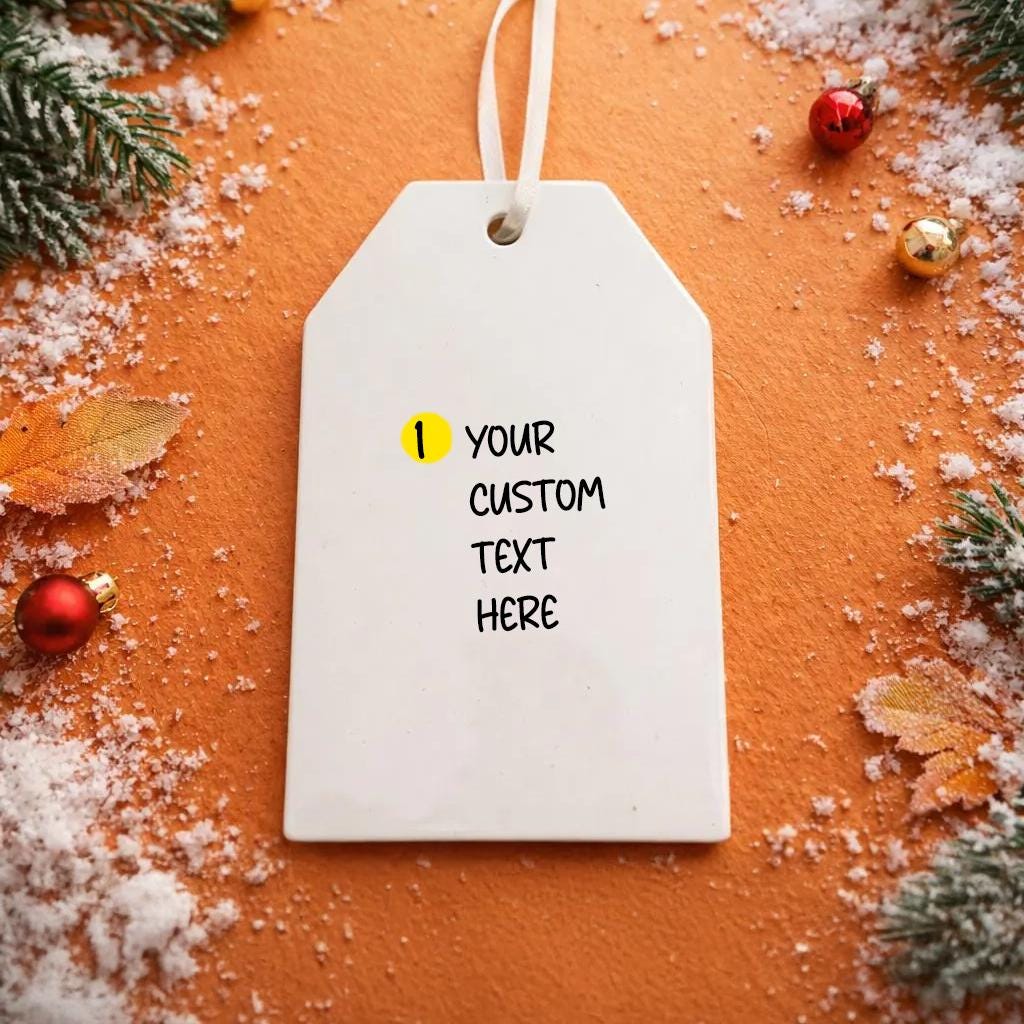 White tag with customizable ornament text on a festive background with Christmas decorations