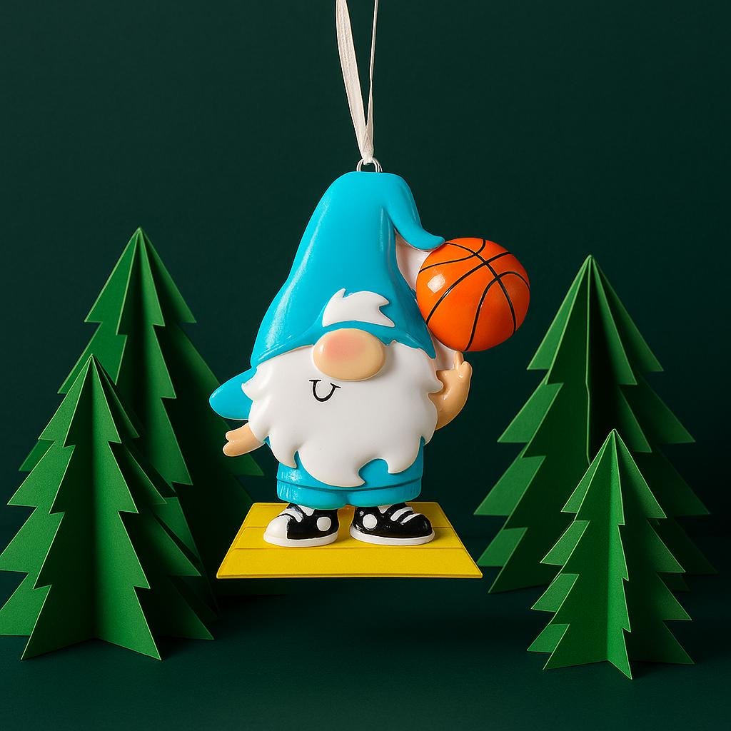 Personalized basketball gnome Christmas ornament featuring a cute blue gnome character holding a basketball, customizable name area on the hat and customizable year area on the base, glossy finish with raised 3D front details and flat 2D back, white hanging ribbon, displayed on a snowy holiday background with pine branches and festive decorations.
