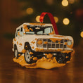 Load image into Gallery viewer, Decorative Christmas ornament shaped like a truck with a red ribbon on a wooden surface.
