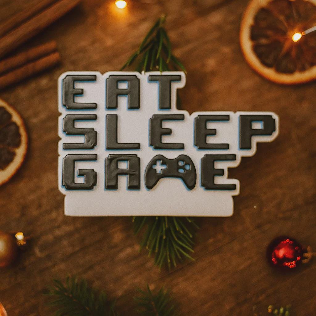 Personalized Eat Sleep Game Christmas ornament with a raised 3D front featuring bold block-style lettering and a detailed game controller icon. The front design is fully three dimensional, creating depth and texture, while the back is flat 2D for easy hanging and durability. White base with black raised letters and subtle colored accents. Includes hand-added personalization with name and year or family name. Gaming-themed holiday ornament displayed on snowy festive background with warm lights, designed for 