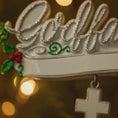 Load image into Gallery viewer, Decorative tiara with 'Godiva' branding and holly leaves on a blurred lights background
