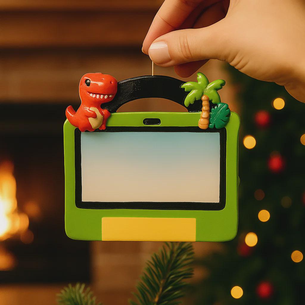 Decorative ornament with a dinosaur and tropical elements on a green background, held by a hand.
