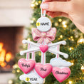Load image into Gallery viewer, Personalized Baby Girl First Christmas Ornament featuring a dimensional 3D front design with pink glitter bow, heart charms, and hanging cloud detail. The baby’s name is added on the top circle and the year on the cloud, creating a meaningful keepsake. Soft pink tones, layered hearts reading Baby’s First Christmas, and festive holiday accents make it perfect for newborn girl gifts, baby shower presents, and treasured Christmas tree memories.
