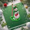 Load image into Gallery viewer, Snowman golf ornament on a green background with festive decorations
