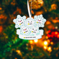 Load image into Gallery viewer, Decorative ornament with snowflakes and smiley faces against a blurred Christmas tree background.
