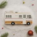 Load image into Gallery viewer, Decorative camper ornament on a textured surface with Christmas decorations.

