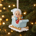 Load image into Gallery viewer, Personalized baby first Christmas ornament featuring a sweet baby boy sitting in a pastel blue sleigh holding a small teddy bear. Handwritten baby name and year displayed on the sleigh front. Smooth resin finish with soft winter tones, lightweight structure, mostly 2D ornament with raised 3D front details, designed for baby boy nursery themed Christmas tree decor and keepsake gifting.
