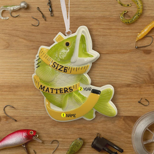 Decorative fish-shaped ornament with 'Size Matters' text on a wooden surface with fishing equipment.