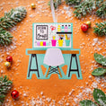 Load image into Gallery viewer, Born to Craft ornament featuring a creative desk scene with colorful craft supplies including scissors paint bottles brushes pencils and storage cups. The ornament showcases a playful crafting workspace design with a modern chair and desk setup. Made from durable resin with a detailed 3D front and flat 2D back for smooth hanging. Includes free handwritten personalization making it a perfect gift for crafters artists DIY lovers and creative kids. Ideal for Christmas trees craft rooms studios and handmade the
