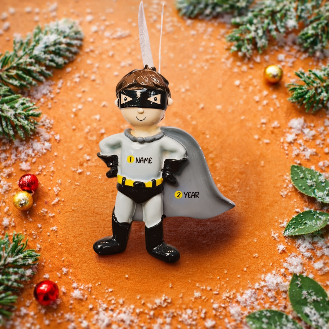 Personalized superhero boy Christmas ornament featuring a mask, cape and custom name. Cute holiday decor for boys, perfect for Christmas trees and gift-giving. Add name and year to create a unique keepsake. Display photos are AI-generated; please check the first image for the original product.
